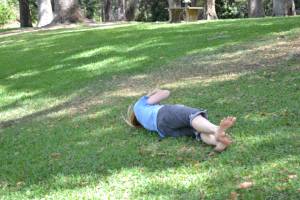 Lisa rolls downhill on the soft grass, laughing hysterically like a five-year old.